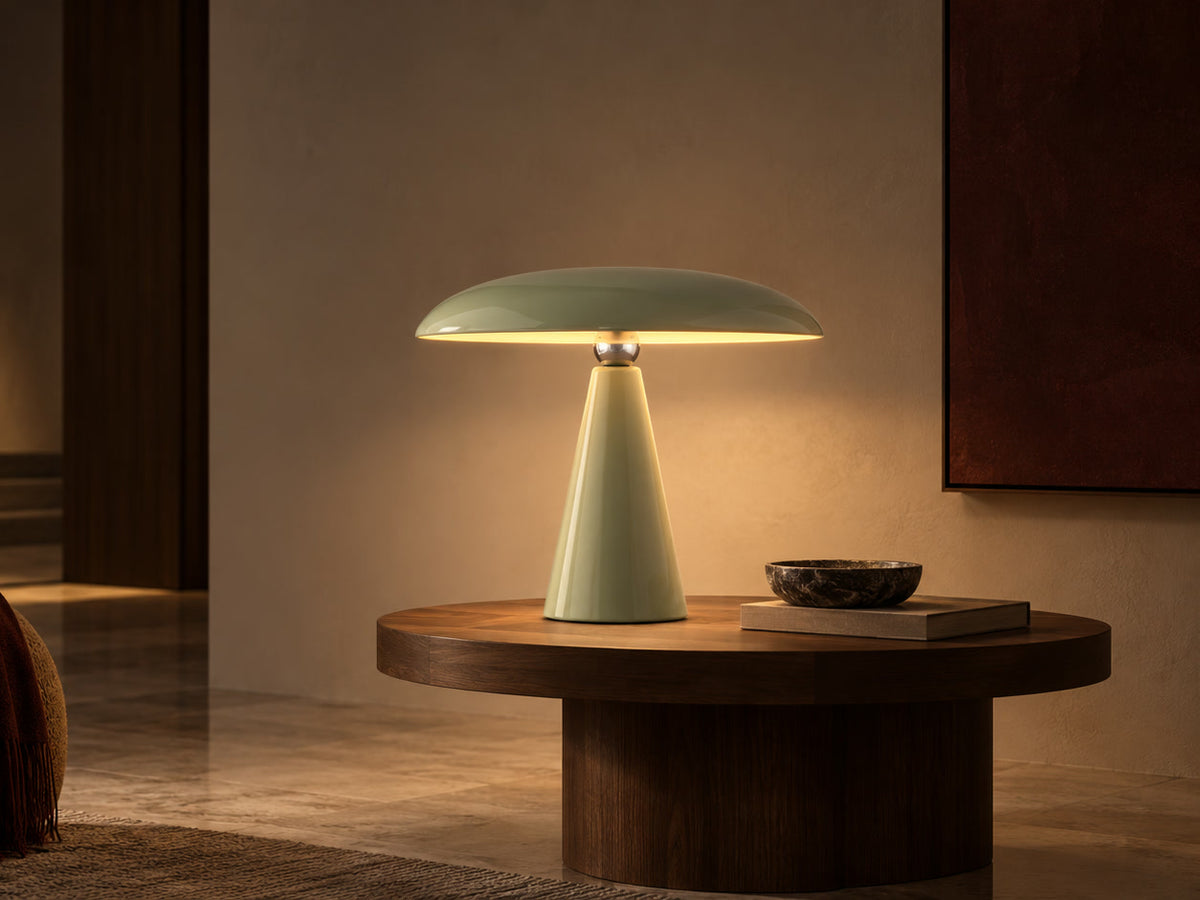 A Zenara mushroom dome lamp glowing on a walnut table
